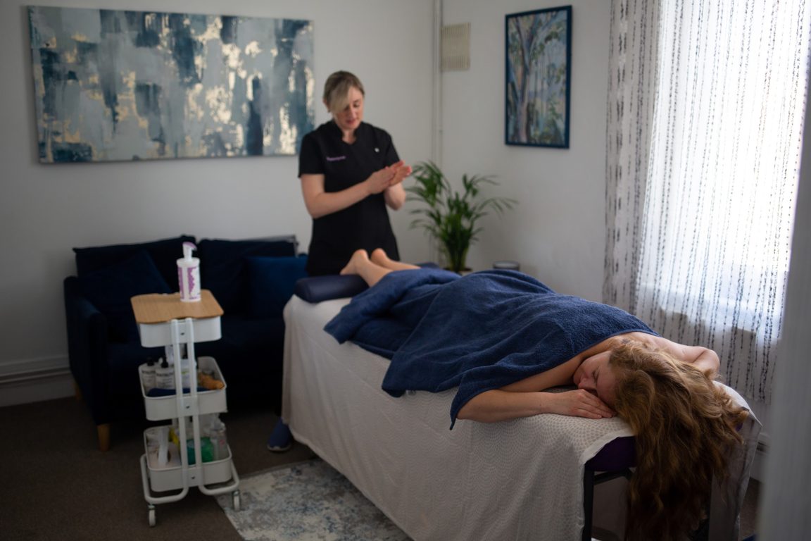 Calm treatment room with warm light, towels and candles